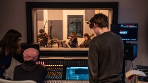 A group of students recording a string quartet in a recording studio
