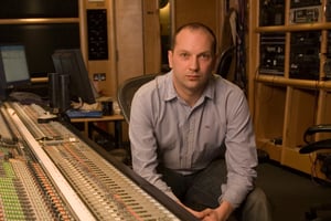Richard Jacques sat beside a large mixing console in a recording studio