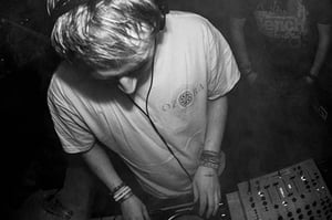 A black and white photo of Chris Rich DJing live