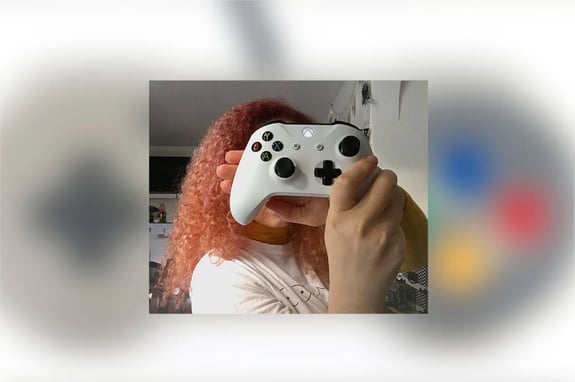 An image of Sabrina Fletcher holding an Xbox One gamepad in front of her face