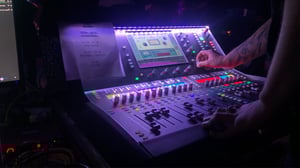 A close up of a live sound student mixing audio for an event