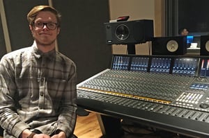 A landscape photo of Sam Brown sat beside the SSL Duality Delta in dBs Bristol